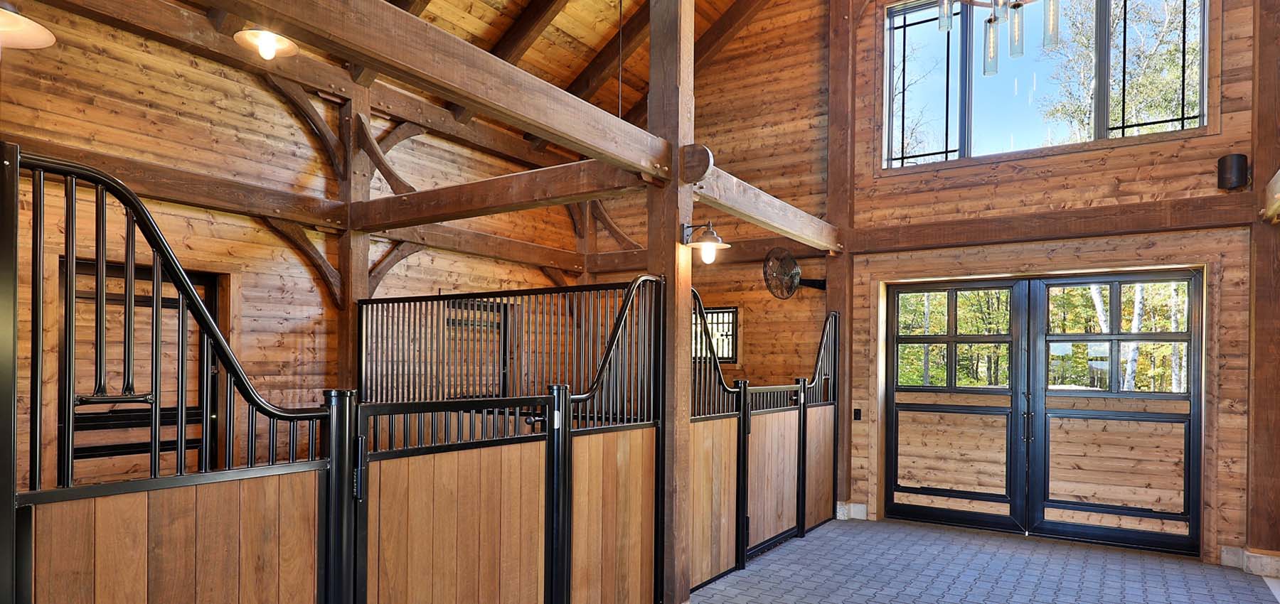 Private barn interior Low European Series hinged-door stall fronts and barn end door