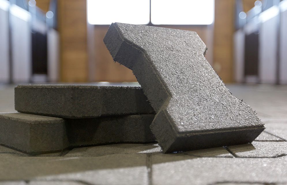 True-Step® paver blocks stacked for display on barn flooring that has TrueStep pavers installed.