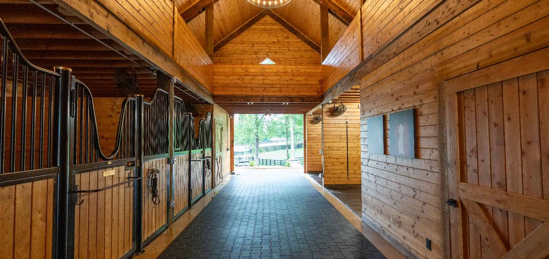 High Euro stall front with yoke opening. Barn end doors open and overlooking paddocks.