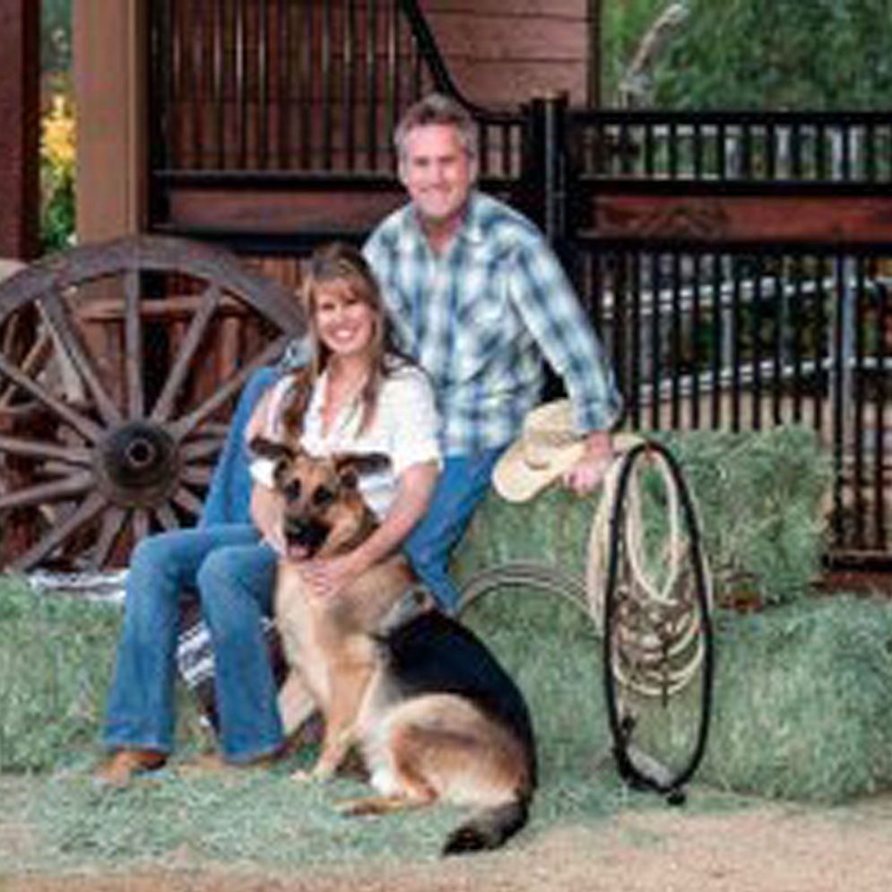 SAndy Froehlich with family and dog in front of low European horse stall fronts