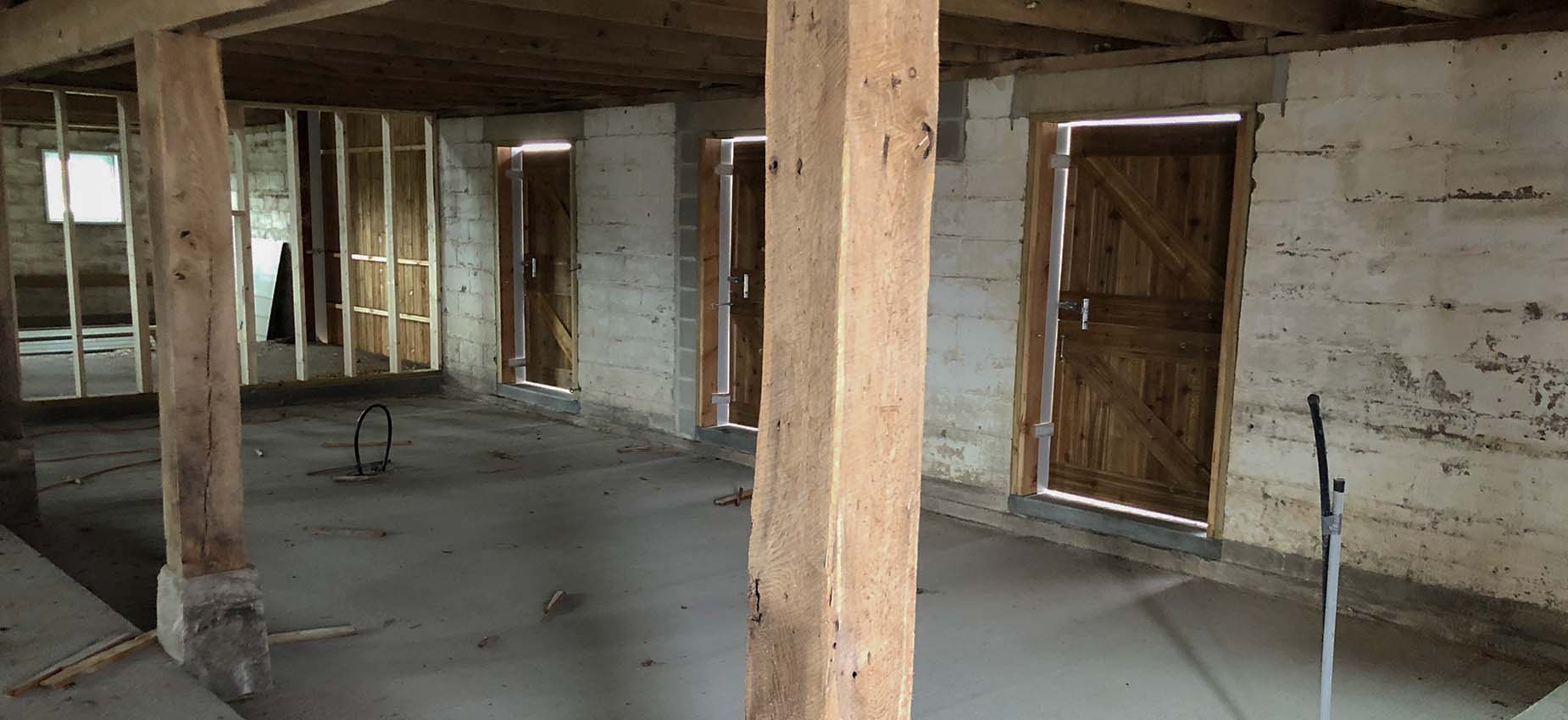 A room with exposed wooden beams and a wooden door.