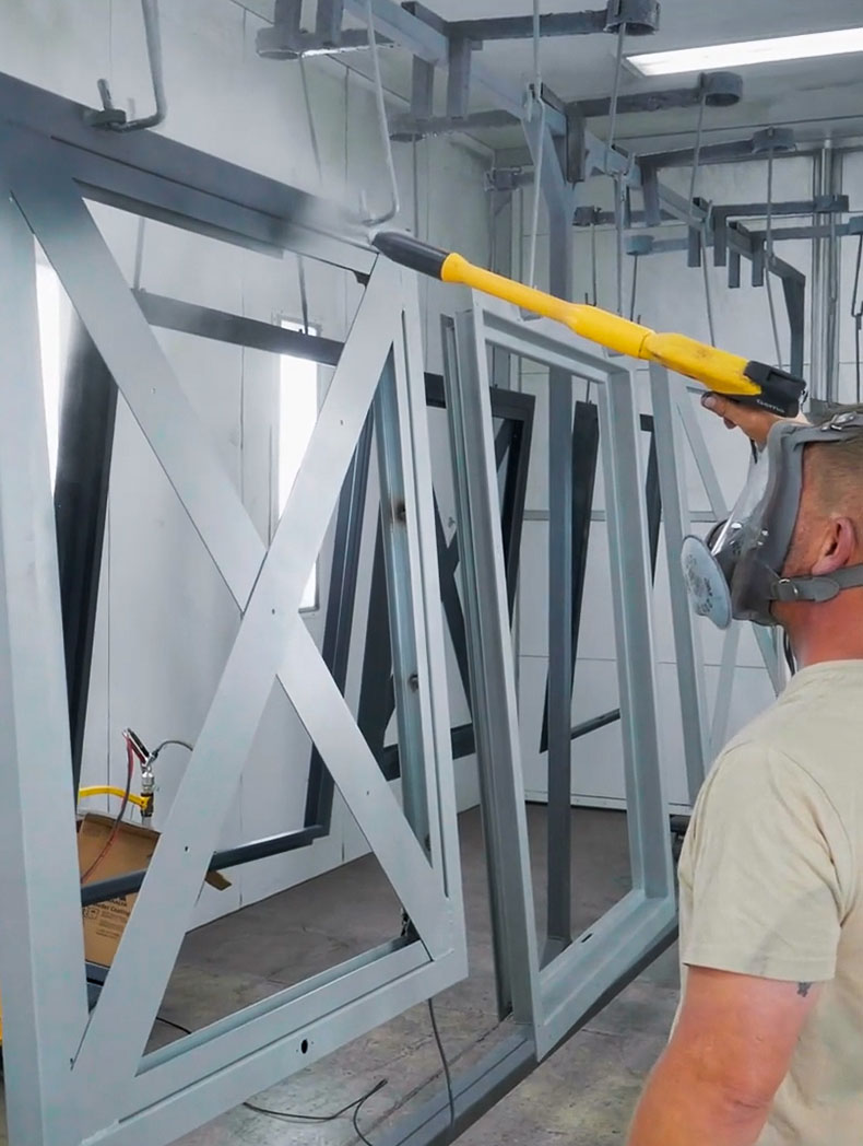 A man spraying a window frame.