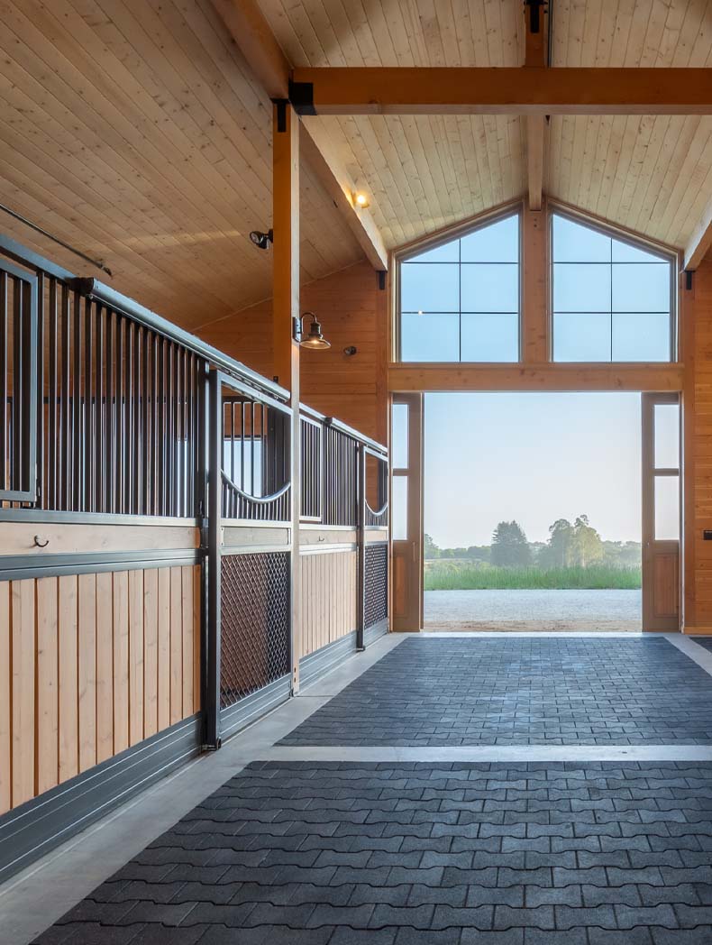Santa Cruz Barn Project. Interior of a horse barn sliding stall doors, yoke top and mesh stall fronts. Spacious window and barn door
